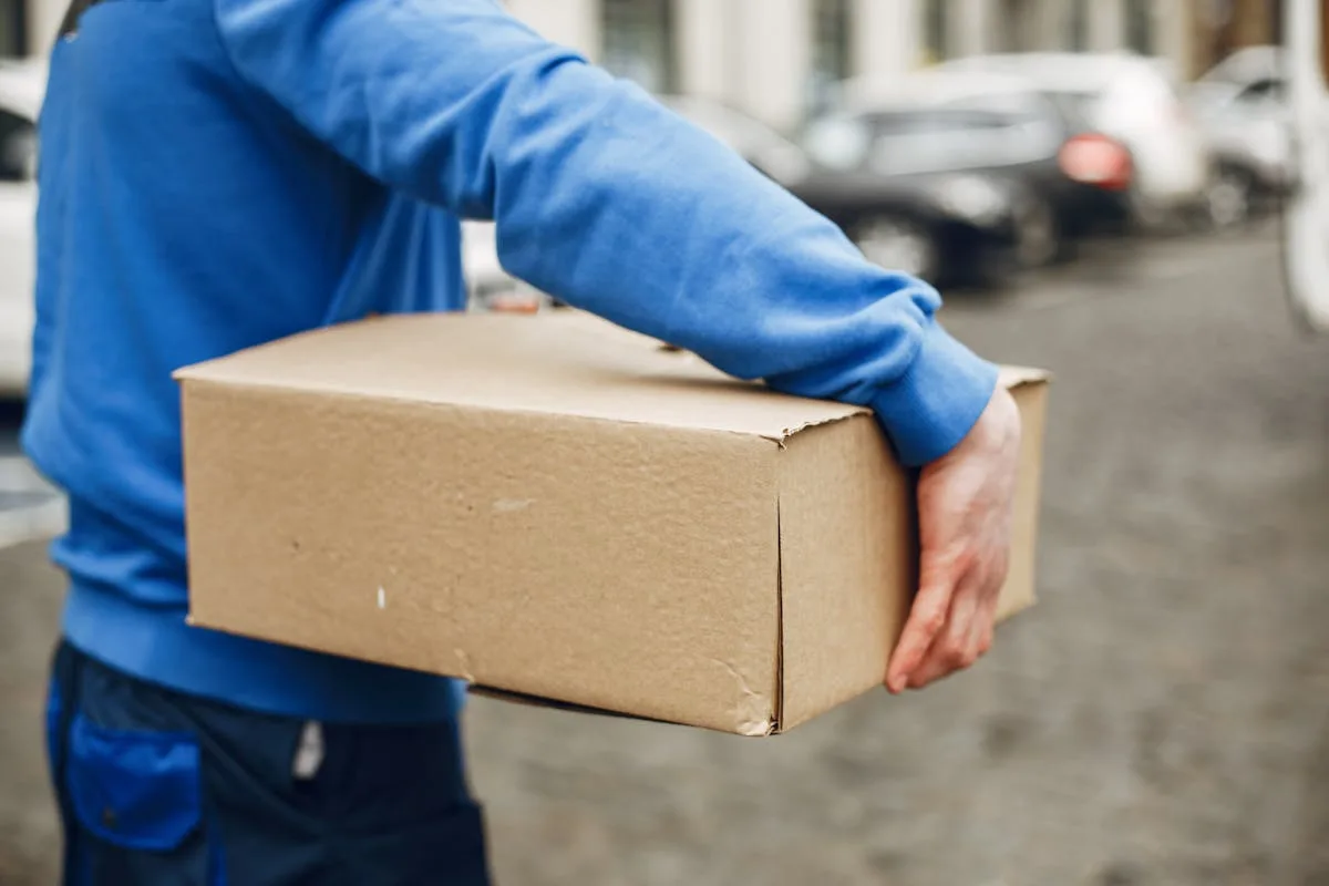 A WOOW courier carrying a parcel for fast express delivery to Bangladesh